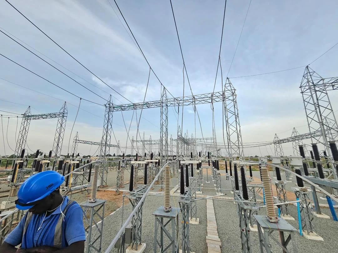 High-voltage power substation with transmission towers against open sky